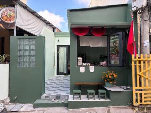 a green building with a table and chairs in front of it at Êm Êm Homestay Đảo Lý Sơn in Ly Son
