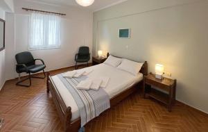 a bedroom with a bed with two chairs and a desk at Villa Evgenia in Yénion