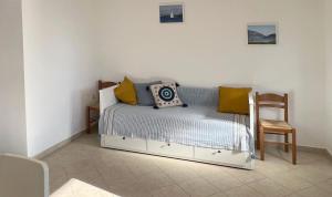 a bedroom with a bed with yellow pillows and a chair at Villa Evgenia in Yénion +8 photos