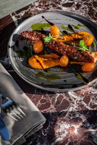 a plate of food with carrots on a table at The Stanley in Athens