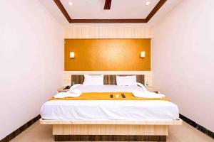 a bedroom with a large bed with a wooden headboard at Hotel DRG Heritage in Tiruppūr