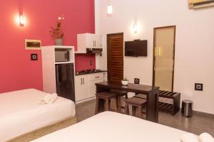 a room with a kitchen with a table and a room with two beds at Abie Villa in Negombo