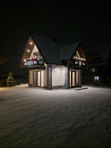 a lit up building at night with lights at Family House B in Witów
