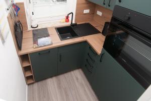 a small kitchen with a sink and a stove at Leichte Brise 2 Greetsiel in Krummhörn