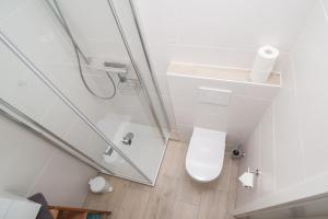 a bathroom with a toilet and a glass shower at Leichte Brise 2 Greetsiel in Krummhörn +6 photos