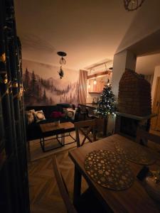a living room with a christmas tree on the wall at Family House B in Witów
