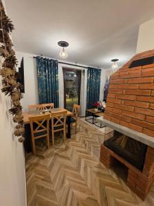 a living room with a table and a brick fireplace at Family House B in Witów +10 photos