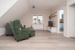 a living room with a chair and a tv at Leichte Brise 2 Greetsiel in Krummhörn