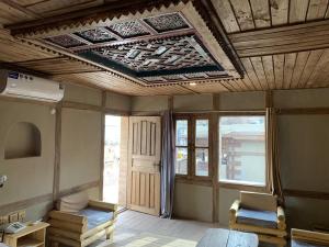 a living room with a coffered ceiling and windows at Zimsa Resort Skardu in Skardu