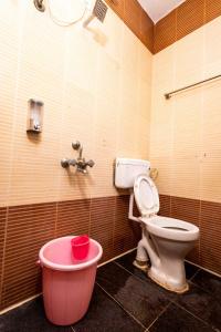 a bathroom with a toilet and a pink bath tub at Hotel DRG Heritage in Tiruppūr