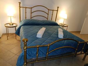 a bedroom with a bed with blue sheets and two lamps at Ai piedi del Morrone in Tocco da Casauria