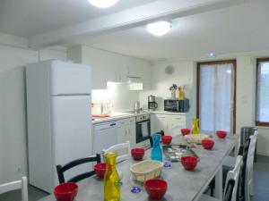 a kitchen with a long table with red bowls on it at auberge de louroux in Louroux-de-Bouble +3 photos