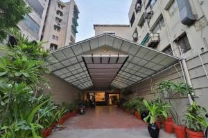 a building with awning over a courtyard with plants at Hotel Kanak in Ahmedabad