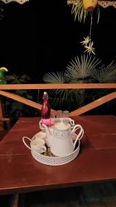 a teapot and cups on a wooden table at MountainBrew Homestay in Takdāh