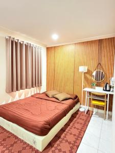 a bedroom with a bed and a table with a lamp at Dedbaicha cafe & Hostel Phuket old town in Phuket