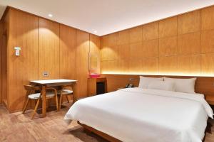 a bedroom with a large bed and a table at Hotel Coolstay Gimcheon in Gimcheon +52 photos