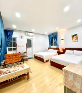 a hotel room with two beds and a couch at New Sala Homestay in Hue