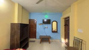 a living room with a tv on a blue wall at Rama Guest House in Bodh Gaya