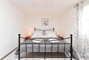 a bedroom with a black bed in a white room at House Kanižela 2418 in Nova Vas