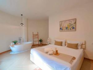 a bedroom with a large bed and a bath tub at Rabbit Villa Bangsaray in Bang Sare