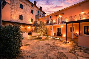 a courtyard of a building with a tree in front of it at House Kanižela 2418 in Nova Vas