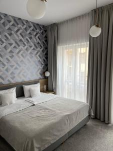 a bedroom with a large bed and a window at Ermine Suites in Krakow