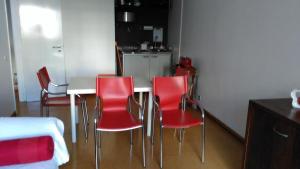 a kitchen with a table and red chairs in a room at Apartamento Avenida 5 de Outubro in Lisbon