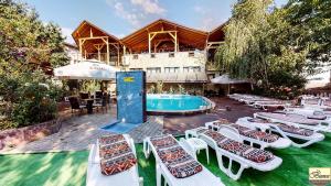 a group of lounge chairs next to a swimming pool at Pensiunea Bianca in Botoşani