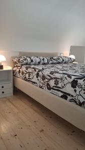 a bedroom with a bed with a black and white comforter at Dimora Rosella in Tramonti