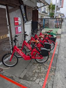 a row of red bikes parked next to a building at 旅の途中 On the trip in Kumamoto