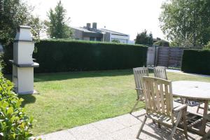 a yard with a table and two chairs and a bird house at Heggerank 3A in Nieuwvliet +3 photos