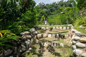 a woman walking through a garden with a herd of sheep at ONE Santuario Natural in Palomino +42 photos