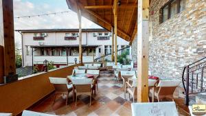 a restaurant with tables and chairs on a balcony at Pensiunea Bianca in Botoşani