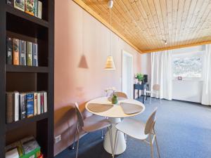 a room with a table and chairs and a book shelf at Boutique73 Sunrise in Ossiach