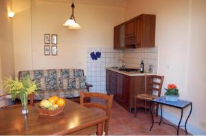 a kitchen and a living room with a table and chairs at Agriturismo Casanova in Asciano +13 photos