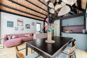 a living room with a table and a pink couch at Forest Villa De Bosburcht with Sauna | 6 persons in Gasselte