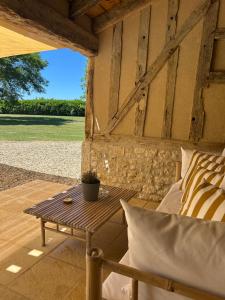 a patio with a table and a couch on a porch at Le Grand Chene in Moustier