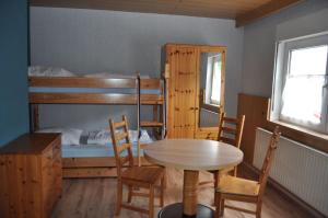 a room with a table and chairs and a bunk bed at Suederhof-Diemelsee in Diemelsee