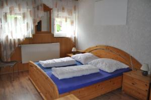 a bedroom with a wooden bed with two pillows at Suederhof-Diemelsee in Diemelsee