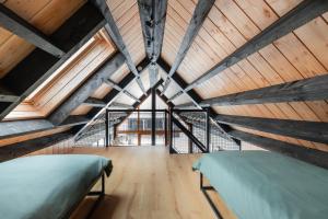 a bedroom with two beds in a wooden ceiling at Forest Villa De Bosburcht with Sauna | 6 persons in Gasselte