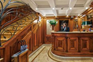 a woman standing behind a wooden bar in a room at Bellevue Luxury Rooms - San Marco Luxury in Venice