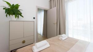 a white bedroom with two towels on a bed at Sol Marina - Marina 165 in Wiślinka +11 photos