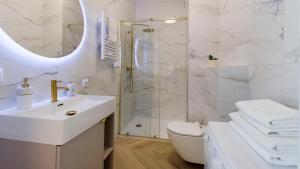 a white bathroom with a shower and a sink at Sol Marina - Marina 165 in Wiślinka