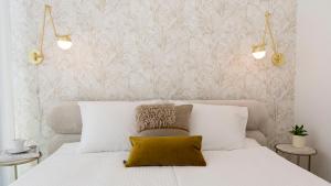 a bedroom with a white bed with a yellow pillow at Sol Marina - Marina 165 in Wiślinka