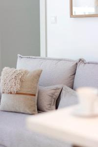a couch with pillows on it in a living room at Sol Marina - Marina 165 in Wiślinka