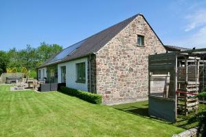 a stone house with a grassy yard in front of it at The Steading InThePark in Stirling