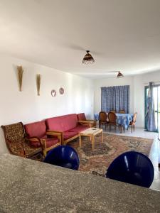 a living room with a red couch and a table at Golden Beach 2 Resort in Ras Sedr