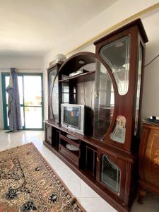 a entertainment center with a tv and a mirror at Golden Beach 2 Resort in Ras Sedr