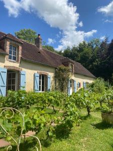 an old house with a garden in front of it at Chambre d'Hôtes La Ferme du Pré-Martin in La Génevraie