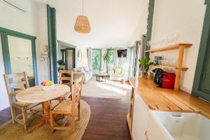a kitchen and living room with a table and chairs at Mas Des Fleurs - Olive House in Perpignan
